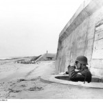 German Obergefreiter inspects area with binoculars. France, the Atlantic Wall, south of the city of Bordeaux. (Spring 1944). Source: German Federal Archive, # Bild 1011-263-1580-13.