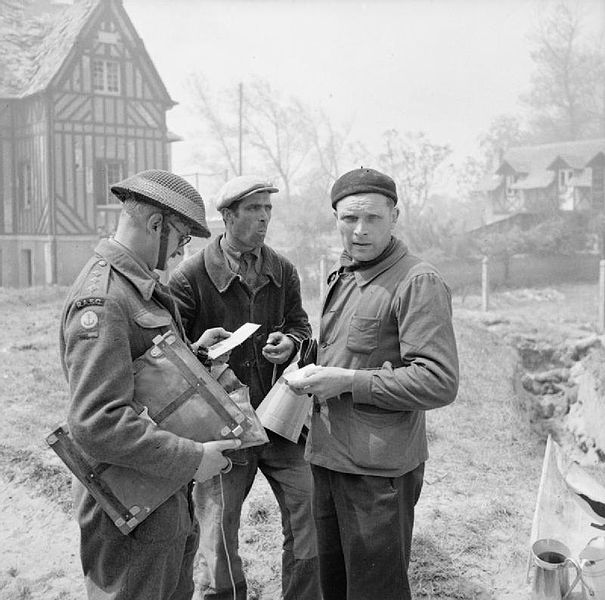French civilians show their identity cards to a British Royal Army Service Corps captain in Lion-sur-Mer. (June 6, 1944). Source: Imperial War Museums, B 5042.