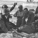 Army medics administering blood plasma to a survivor of a sunken landing craft on Omaha Beach during D-Day. Source: Center of Military History, U.S. Army.