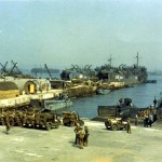 Port in England; in foreground, jeeps are being loaded onto landing craft tanks. (June 1944). Source: Center of Military History.