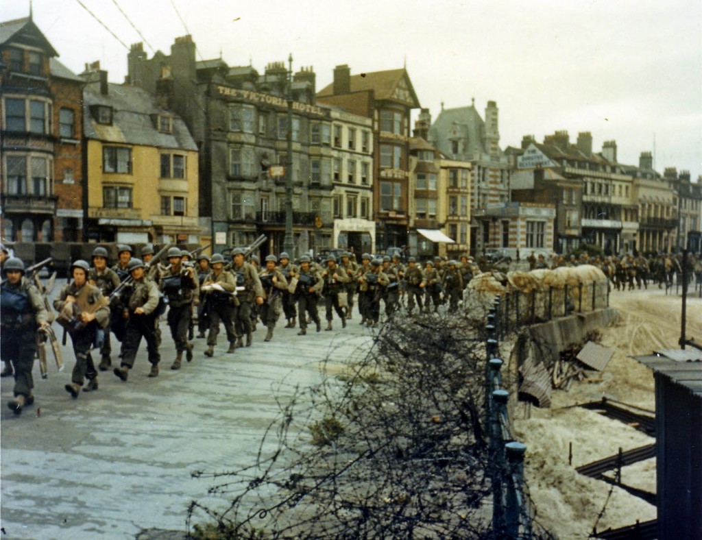 American troops marching through a British port town on their way to the docks. (June 1944). Source: Center of Military History.