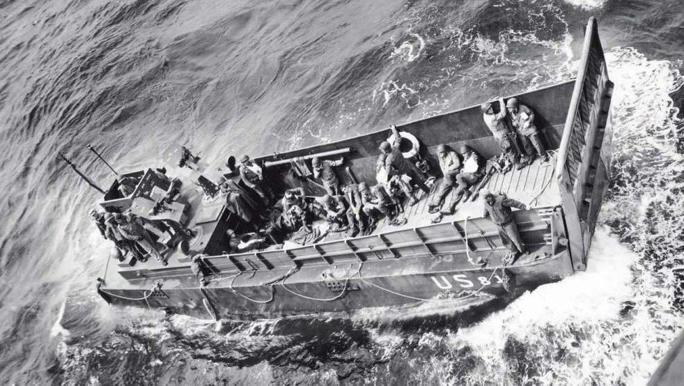 A U.S. Coast Guard landing craft brings wounded U.S. soldiers out to a transport for evacuation from the combat zone. (June 6, 1944). Source: U.S. National Archives, # 26-G-2386.