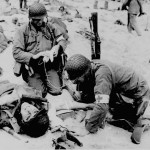 Medic helping injured soldier. France. (1944). Source: U.S. National Archives, # 208-YE-22.