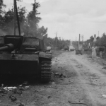 Wrecked German tanks and trucks mark the road of American advancement outside a town in France. St. Mere Eglise, France. (June 10, 1944). Source: U.S. National Archives, # 111-SC-190122.