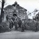 A couple miles from the French beach-head in this little chapel, American soldiers, sailors and Coast Guardsmen attend services for the first Sunday after D-Day. (June 10, 1944). Source: U.S. National Archives, # 26-G-2412.