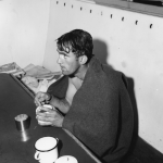 Private William Bonneville, U.S. Army, after an exhausting struggle with the chill currents of the English Channel, is wrapped in a blanket and given hot coffee in the galley of the Coast Guard Rescue Cutter (credited with more than 1,100 rescues since D-Day) that picked him out of the water. Source: U.S. National Archives, # 26-G-2690.