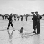 Commodore Douglas-Pennant and his staff interested in one of the mine obstacles found on the French beach-head. (June 1944). Source: Imperial War Museums, A 23945.