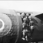 "Angels with dirty faces" --Airborne troops smile from their Horsa glider as they prepare to fly out as part of the second drop on Normandy on the night of D-Day. (June 6, 1944). Source: Imperial War Museums, H 39182.