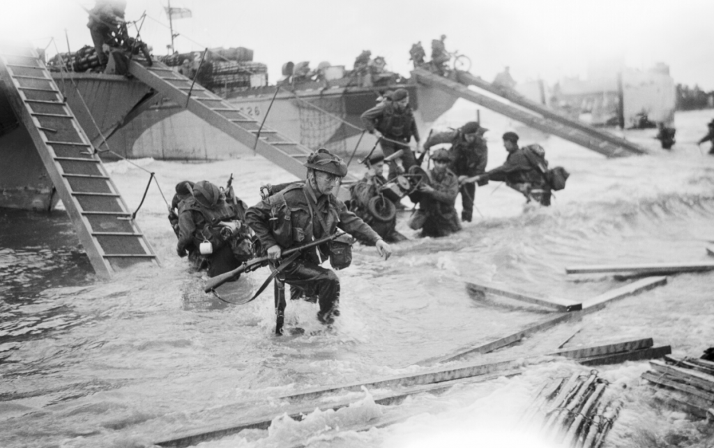 Royal Marine Commandos of the 4th Special Service Brigade make their way onto the 'Nan Red' sector of Juno Beach at St. Aubin-sur-Mer, on the morning of D-Day. (June 6, 1944). Source: Imperial War Museums, B 5218.