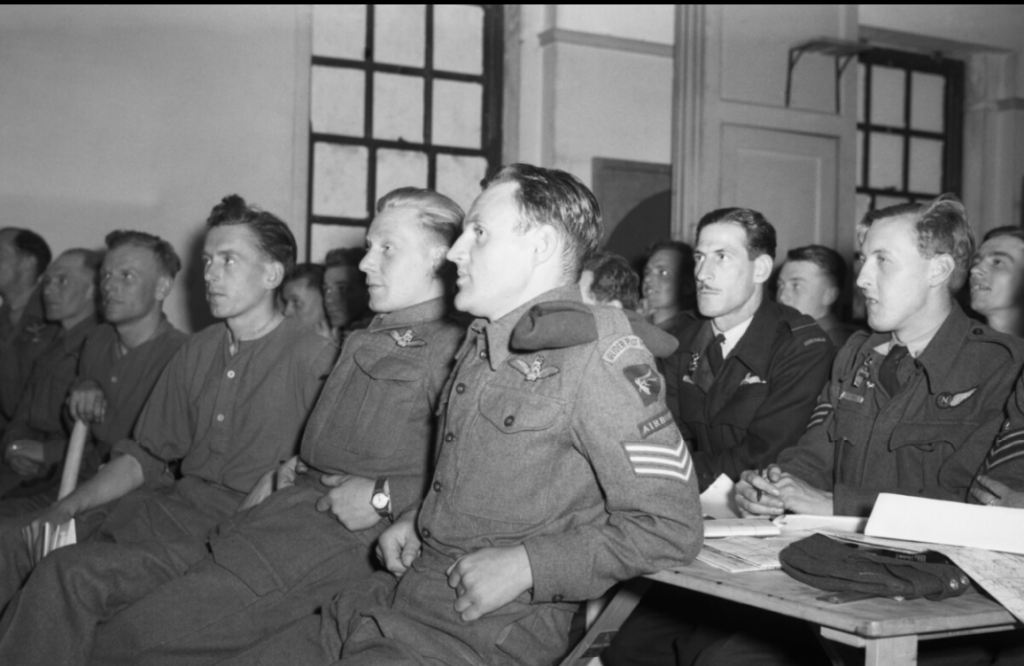 Glider pilots of 6th Airborne Division and RAF crews are briefed at RAF Harwell for the D-Day invasion. (June 5, 1944). Source: Imperial War Museums, # H 39062.
