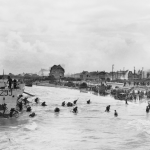 Follow-up waves of the 9th Canadian Infantry Brigade disembarking with bicycles from landing craft onto 'Nan White' sector of Juno Beach at Bernieres-sur-Mer. (June 6, 1944). Source: Imperial War Museums, # A 23938.