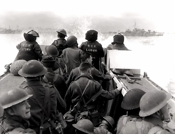Canadian infantrymen aboard a landing craft launched from HMCS Prince Henry, off Normandy beach, France. (June 6, 1944). Source: Library and Archives Canada, Photographer: Dennis Sullivan.