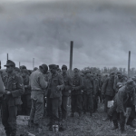 German prisoners being questioned and searched in encampments on Allied beachhead in France. Source: U.S. National Archives, # 80-G-231663.