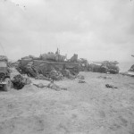 Medics attending to wounded in the lee of a Churchill AVRE from 5th Assault Regiment, Royal Engineers, on Queen beach, Sword area. (June 6, 1944). Source: Imperial War Museums, # B 5095.