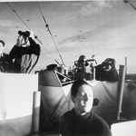The crew on the bridge of the frigate HMS Holmes keep watch as gliders carrying 6th Airborne Division reinforcements to Normandy pass overhead on D-Day. (June 6, 1944). Source: Imperial War Museums, # A 23925.