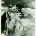 A soldier with his gun outside his tent in Blosville, France. (June 1944). Source: Veterans History Project, Bernard Horowitz.