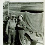 Two soldiers chat outside a military vehicle in France. (June 1944). Source: Veterans History Project, Bernard Horowitz.