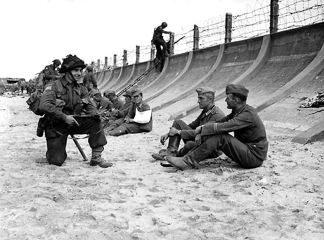 Canadians guarding captured German troops. Berniers Sur Mer, France. (June 6, 1944). Source: Library and Archives Canada.