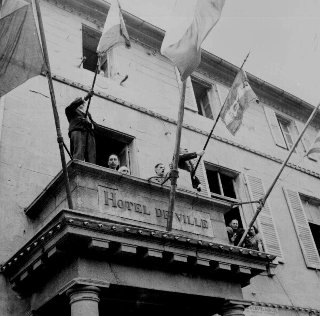 General Charles de Gaulle speaks to the people of Cherbourg from the balcony of the City Hall during his visit to the French port city. (August 20, 1944). Source: U.S. National Archives, # 208-MFI-5H-1.
