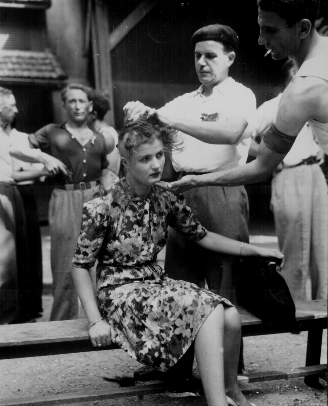 This girl pays the penalty for having had personal relations with the Germans. Here, in the Montelimar area, France, French civilians shave her head as punishment. (August 29, 1944). Source: U.S. National Archives, # 111-SC-193785.