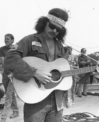 Country Joe McDonald had his own unique style as he rocked the second-day crowd of the original Woodstock Festival. (1969). Source: Woodstock Wikia.