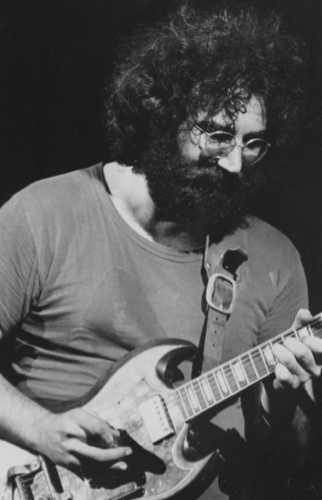 Grateful Dead guitarist Jerry Garcia plays the guitar with passion at the Woodstock Festival. Their set ended up being cut short due to the stage amps overloading. (1969). Source: Woodstock Wikia.