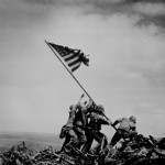 "The First Flag Raising on Mount Suribachi, Iwo Jima," Marines of the 28th Regiment, Fifth Marine Division, hoist the U.S. flag on a piece of pipe. (February 23, 1945). Source: Mark, www.7thfighter.com.